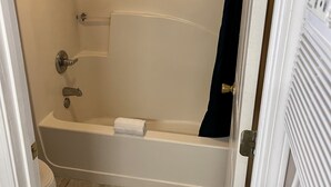 A bathroom with a bathtub, a toilet, and a shower curtain. - Smoky View Inn (Pigeon Forge)
