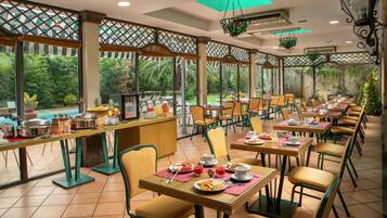 Un ristorante con posti a sedere all'aperto, tavoli e sedie, e un'area buffet.