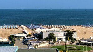 A beachside hotel with multiple rooms, a parking area, and a view of the sea. - Hotel Bristol (Chioggia)
