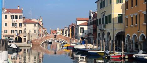 Um canal com uma ponte, barcos e edifícios ao longo da água.