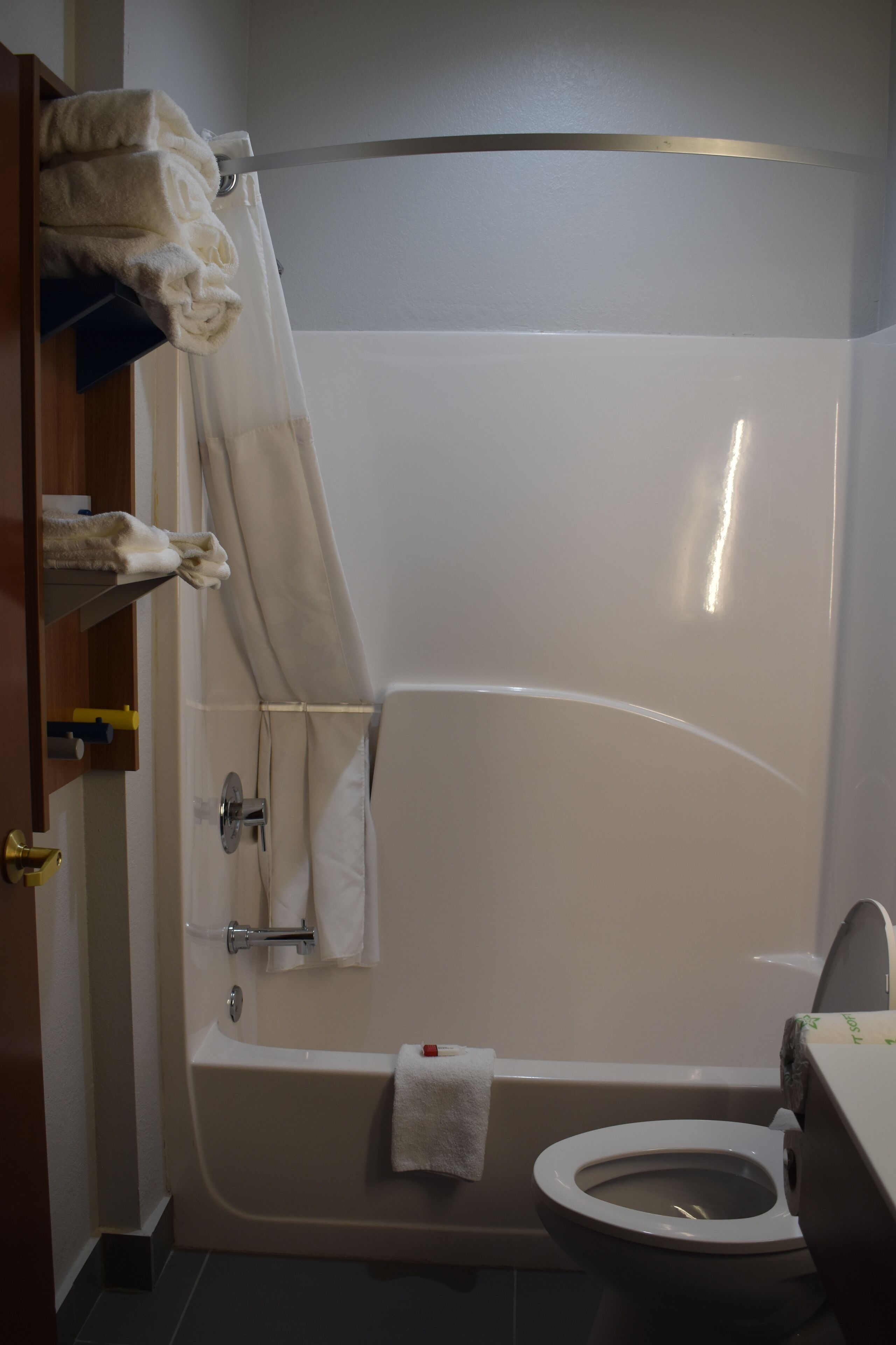 A bathroom with a bathtub, toilet, and a shower curtain.
