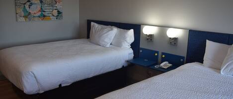 Ein Hotelzimmer mit zwei Einzelbetten, einem Nachttisch mit Telefon und einer Wandleuchte.