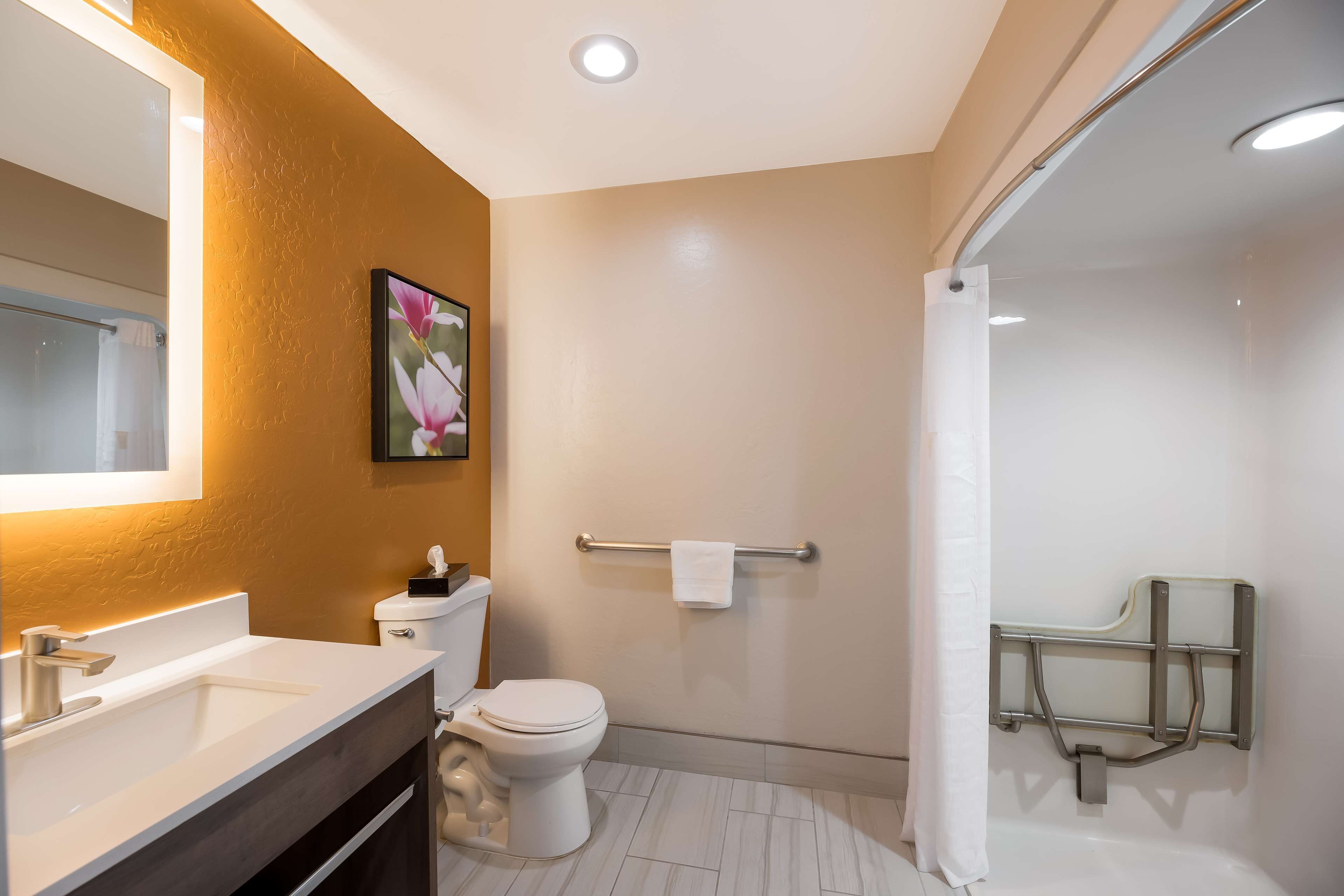 A modern bathroom with a white sink, toilet, and shower.