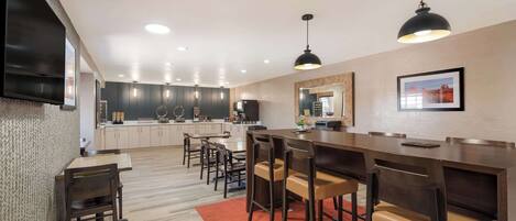 A modern kitchen with dark cabinets, a central island, and pendant lighting.