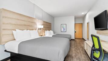Une chambre d’hôtel moderne équipée d’un grand lit, d’un bureau, d’une chaise et d’un téléviseur.
