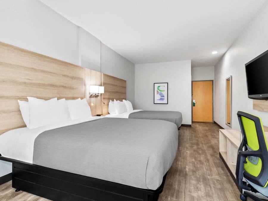 Une chambre d’hôtel moderne équipée d’un grand lit, d’un bureau, d’une chaise et d’un téléviseur.