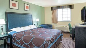 A hotel room with a large bed, a desk, a chair, a television, and two framed pictures on the wall. - Super 8 by Wyndham Sacramento/Florin Rd (Sacramento)