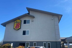 Ein Hotel der Super 8 mit großer Beschilderung, zahlreichen Fenstern und einer Garage.