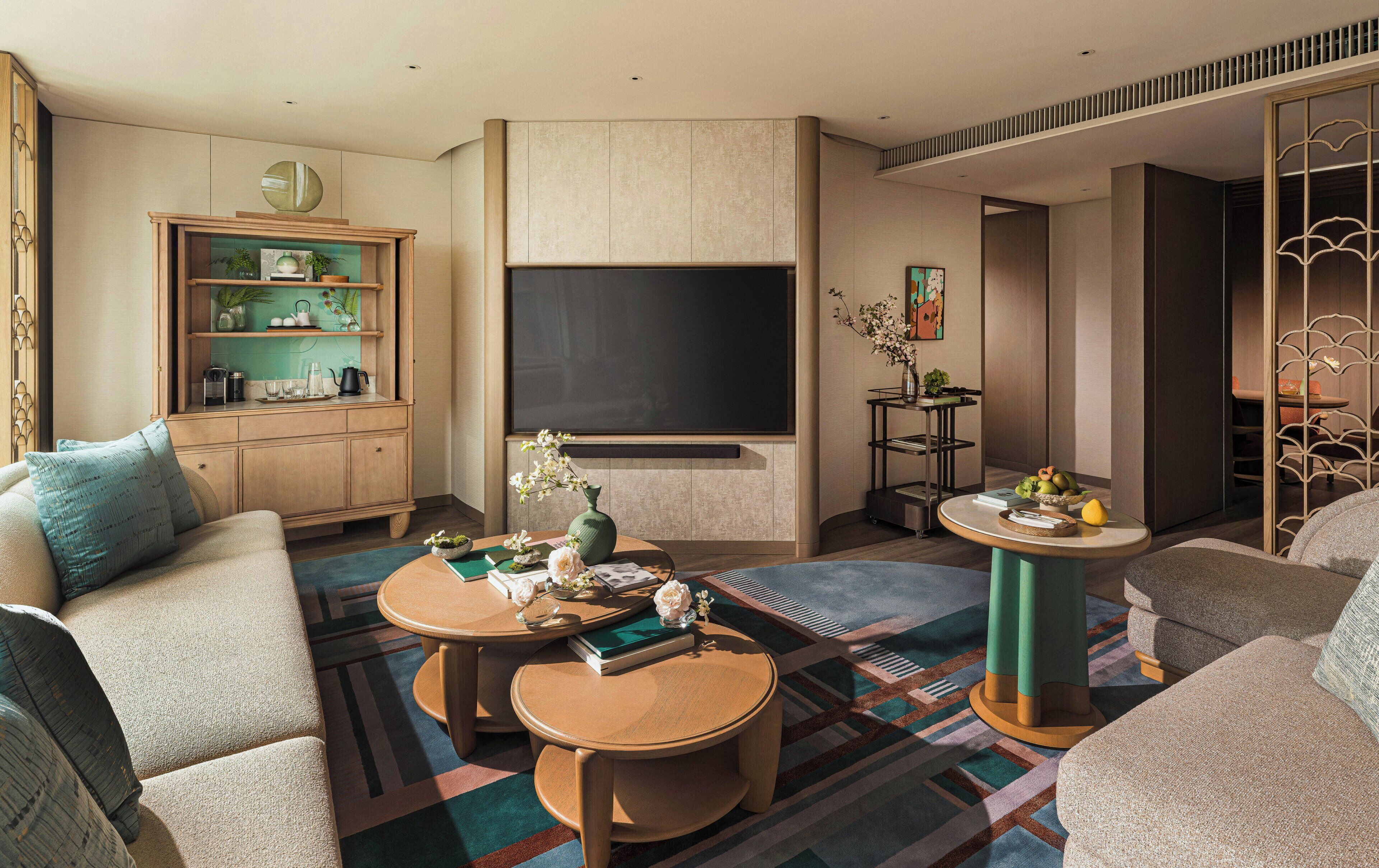 A modern living room with a sofa, coffee table, TV, and decorative items.