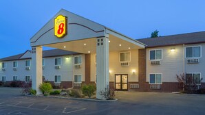 Un hotel Super 8 con entrada cubierta, varias ventanas y estacionamiento.