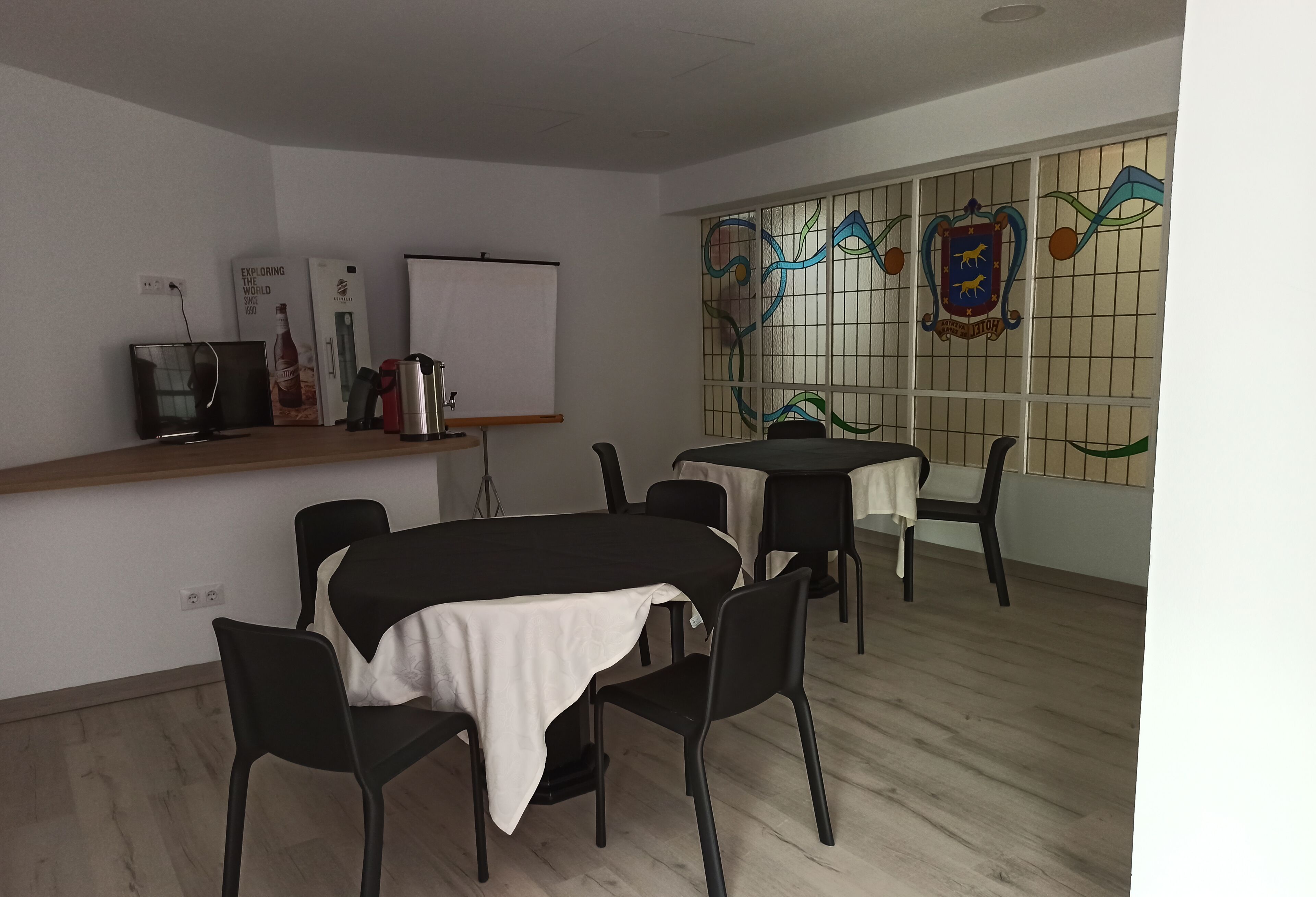 Une salle de conférence équipée d’un tableau blanc, d’un projecteur et d’une table avec des chaises.