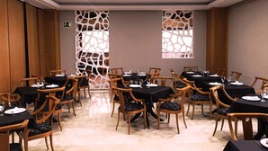 Une salle de conférence dotée de plusieurs tables et chaises, ainsi que de plaques nominatives et de verres.