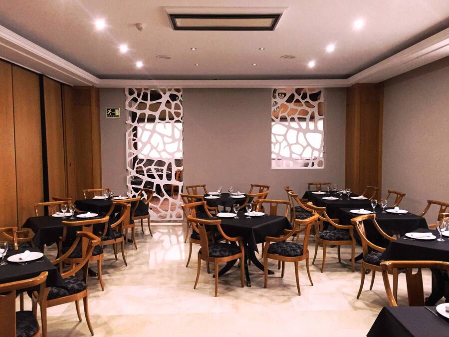 A conference room with multiple tables and chairs, equipped with nameplates and glassware.