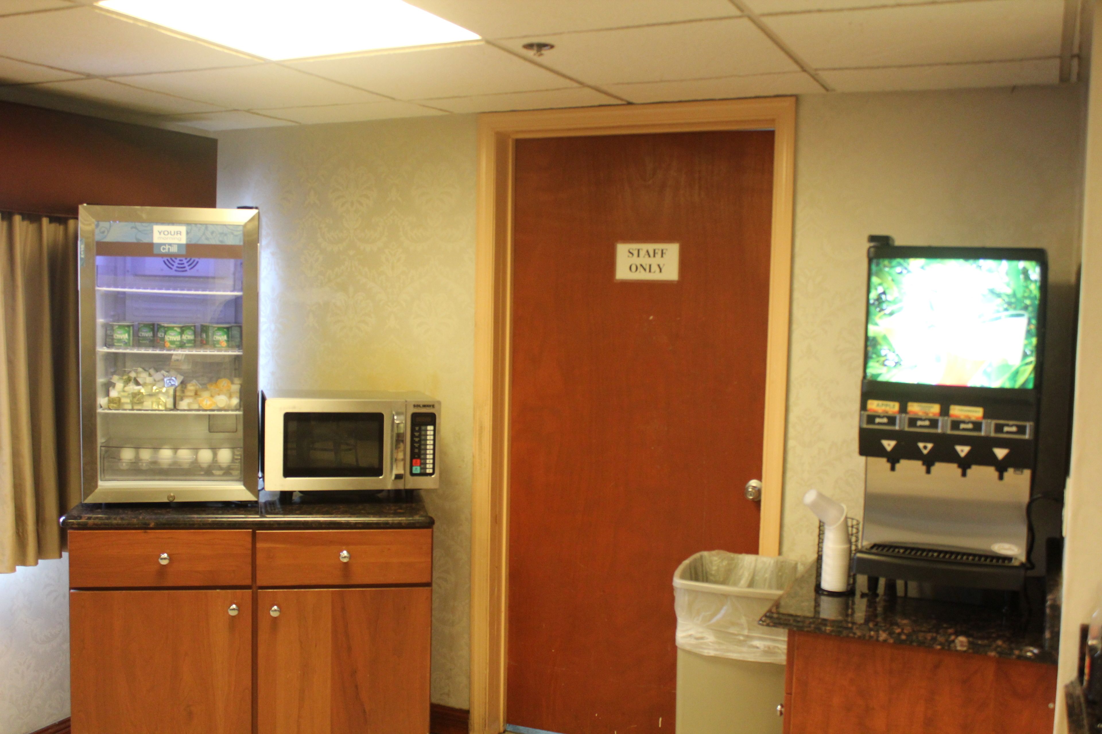 A kitchenette with a microwave, a refrigerator, and a coffee machine.