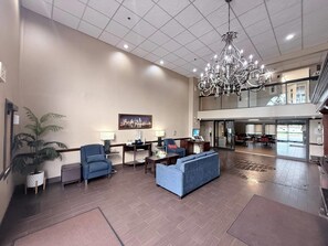 A spacious lobby with a chandelier, seating area, and a large window overlooking the interior. - Comfort Inn Feasterville - Trevose (Feasterville-Trevose)