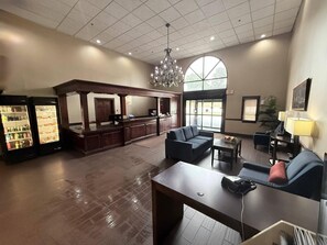 A lobby with a reception desk, seating area, vending machines, and a large window. - Comfort Inn Feasterville - Trevose (Feasterville-Trevose)