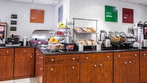 A breakfast bar with various food items, a coffee machine, and a kettle.