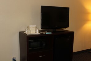 A dark wooden cabinet with a flat-screen TV, a microwave, and a small refrigerator. - Comfort Inn Feasterville - Trevose (Feasterville-Trevose)