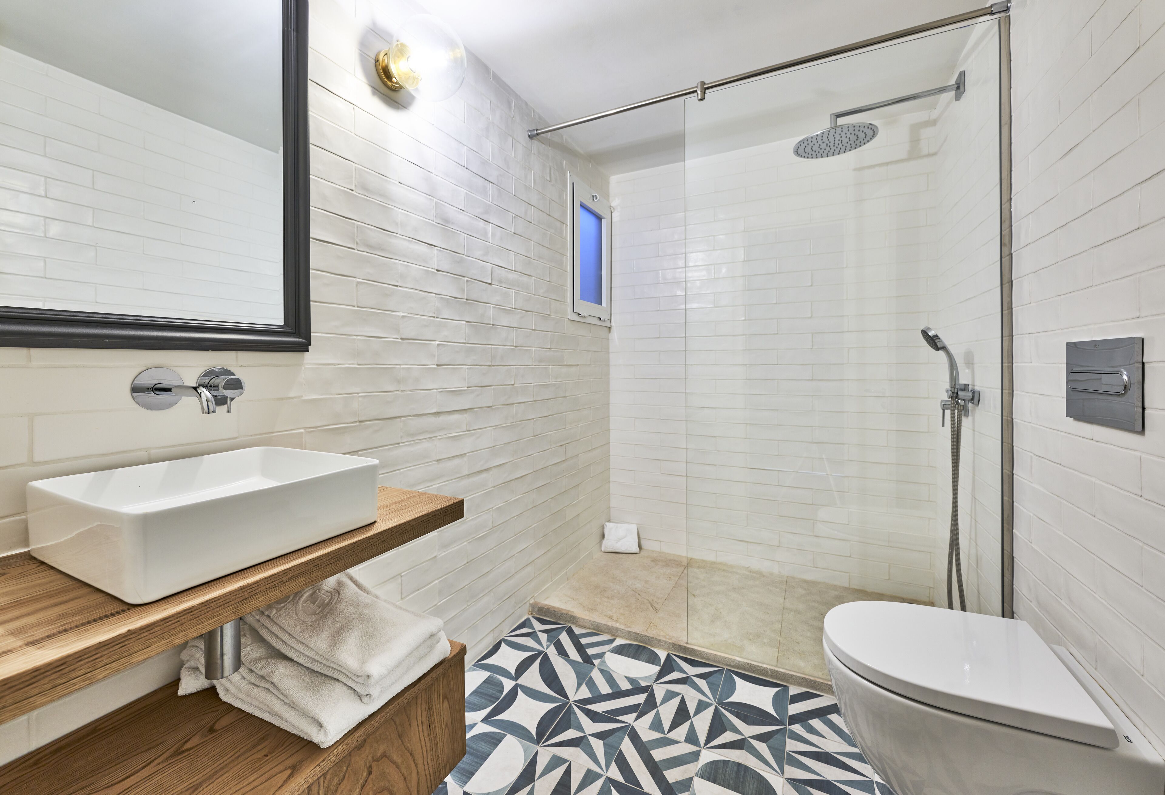 A modern bathroom with a rectangular sink, a toilet, and a shower area.