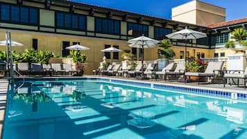 Alberca al aire libre, sombrillas en la alberca y camastros