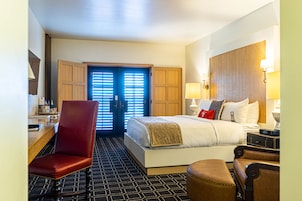Una habitación de hotel con cama, escritorio, silla y armario.