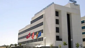 A modern hotel building with multiple flags, including the European Union flag, and a sign indicating it is a hotel. - Eco Via Lusitana (Madrid)