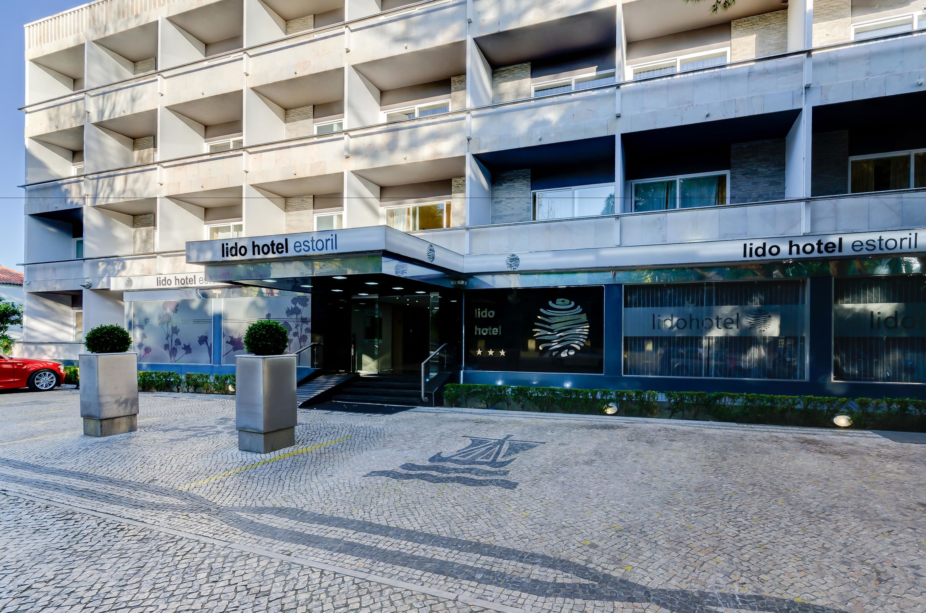 Un hôtel moderne, avec un bâtiment à la façade plate, de nombreux balcons et une entrée bien définie.