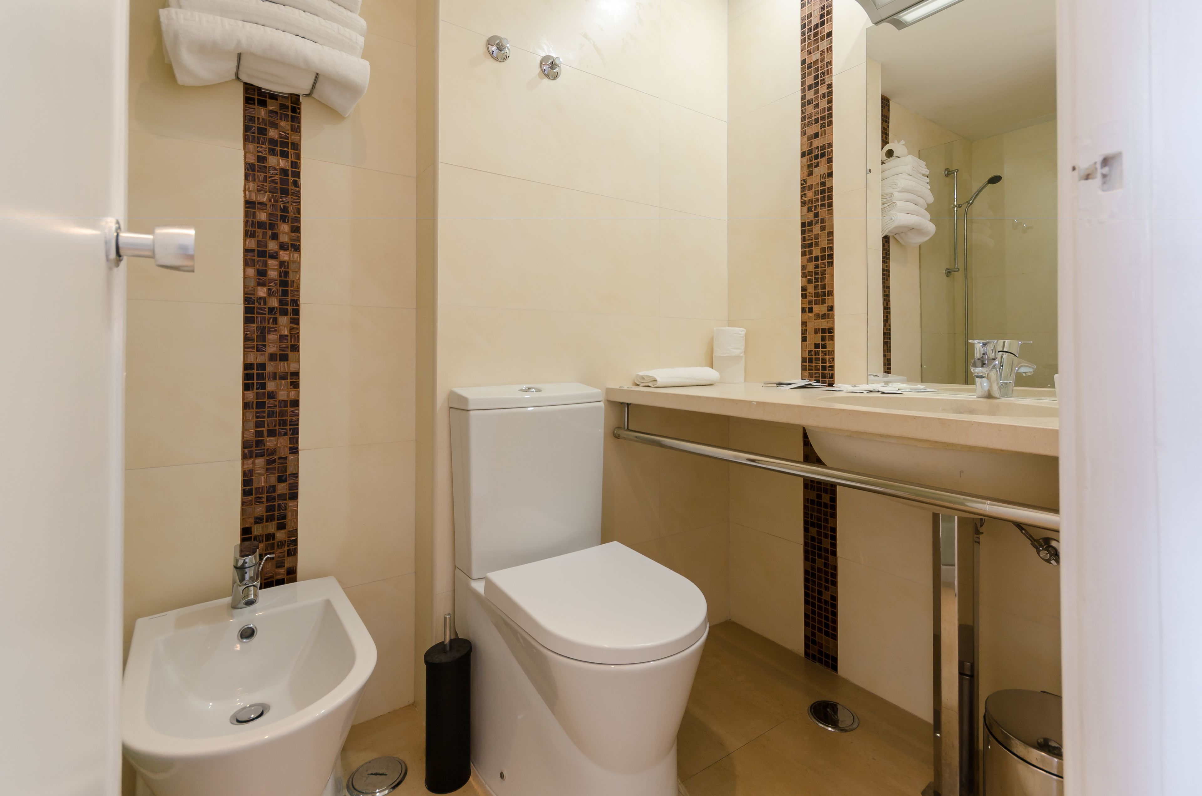 A modern bathroom with a toilet, bidet, and sink.