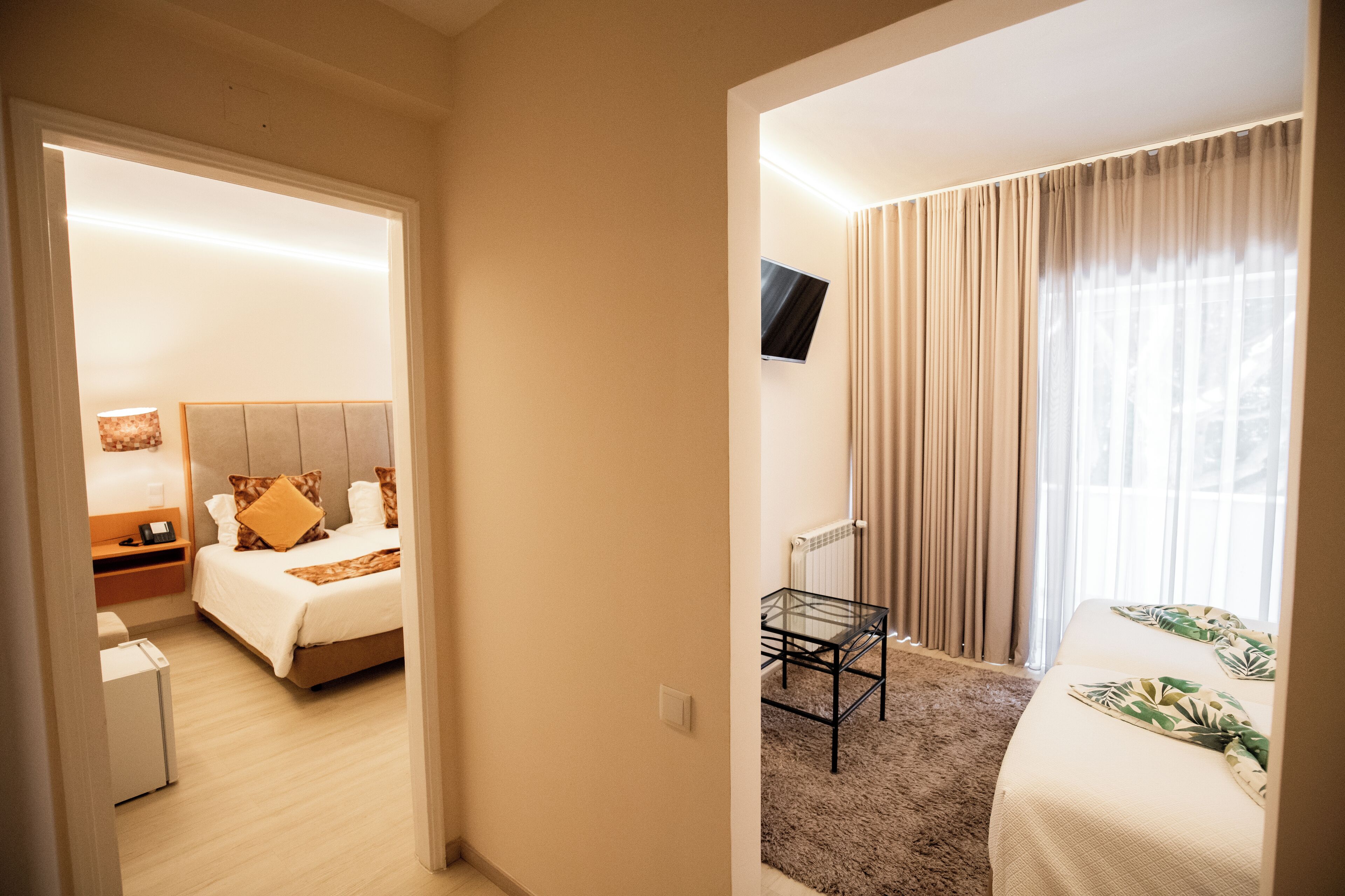 Une chambre d’hôtel équipée d’un lit, d’une table de chevet, d’une lampe et d’un téléviseur fixé au mur.