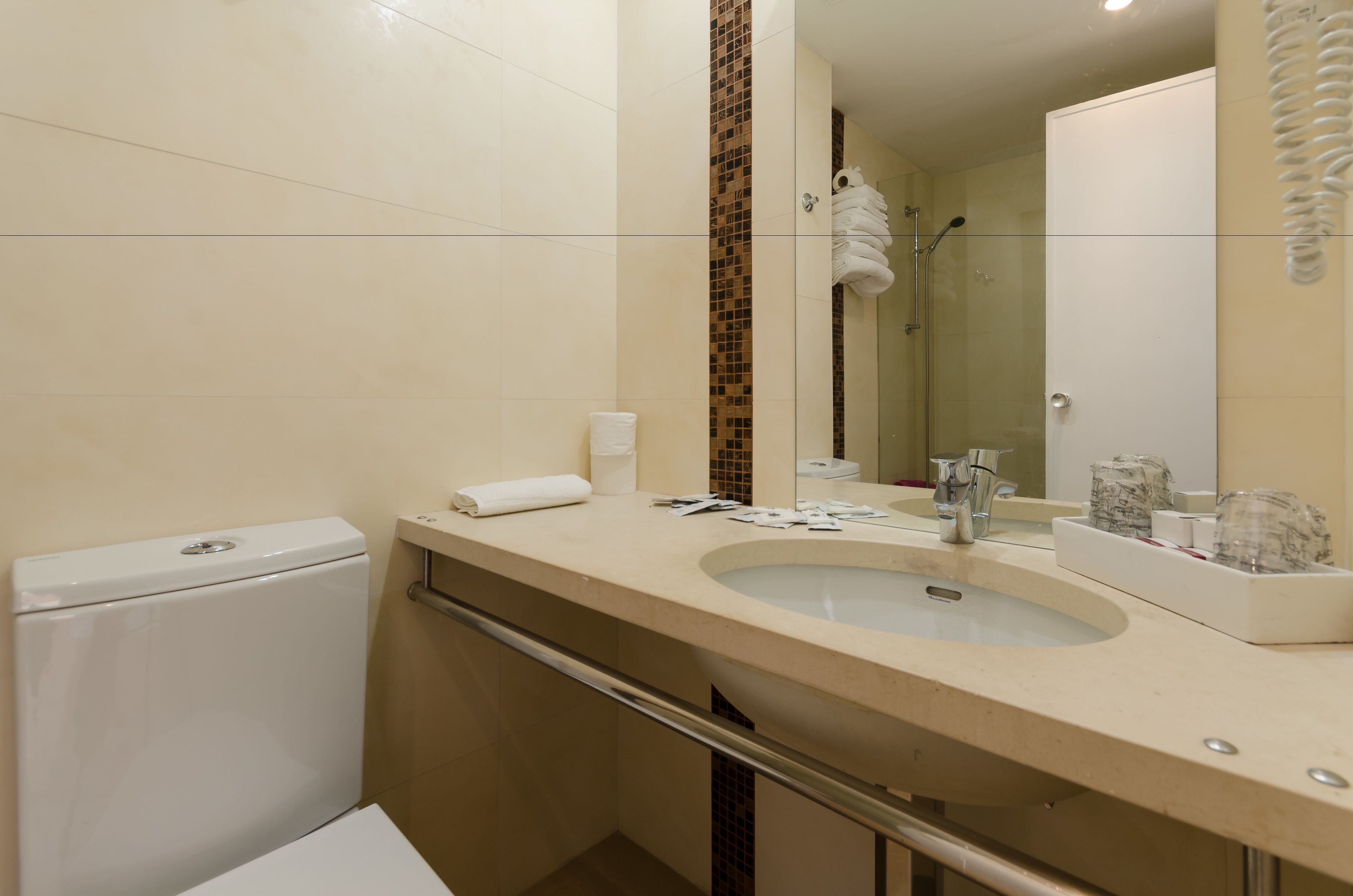 Un baño con inodoro, lavamanos y espejo.