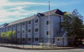 A multi-story building with a flat roof and a flagpole. - Sturbridge Hotel (Sturbridge)