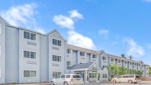A hotel with a central entrance, multiple floors, and a parking area. - Sturbridge Hotel (Sturbridge)
