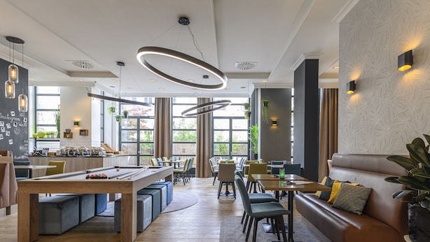 A modern lounge area with a pool table, seating, and a bar. - Holiday Inn Brussels Schuman by IHG (Brussels)
