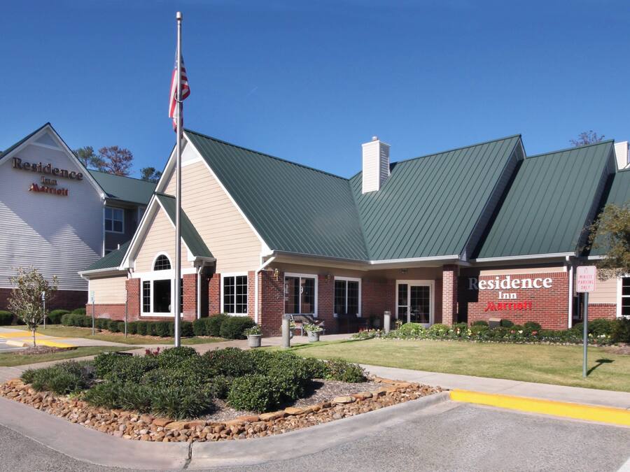 A hotel with a green roof, brick facade, and a sign reading "Residence Inn".