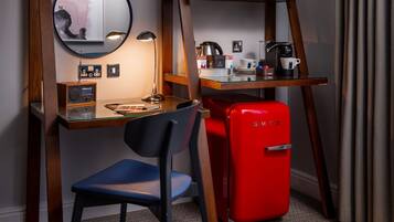 Un espacio de trabajo funcional con escritorio, silla y un refrigerador rojo Smeg.