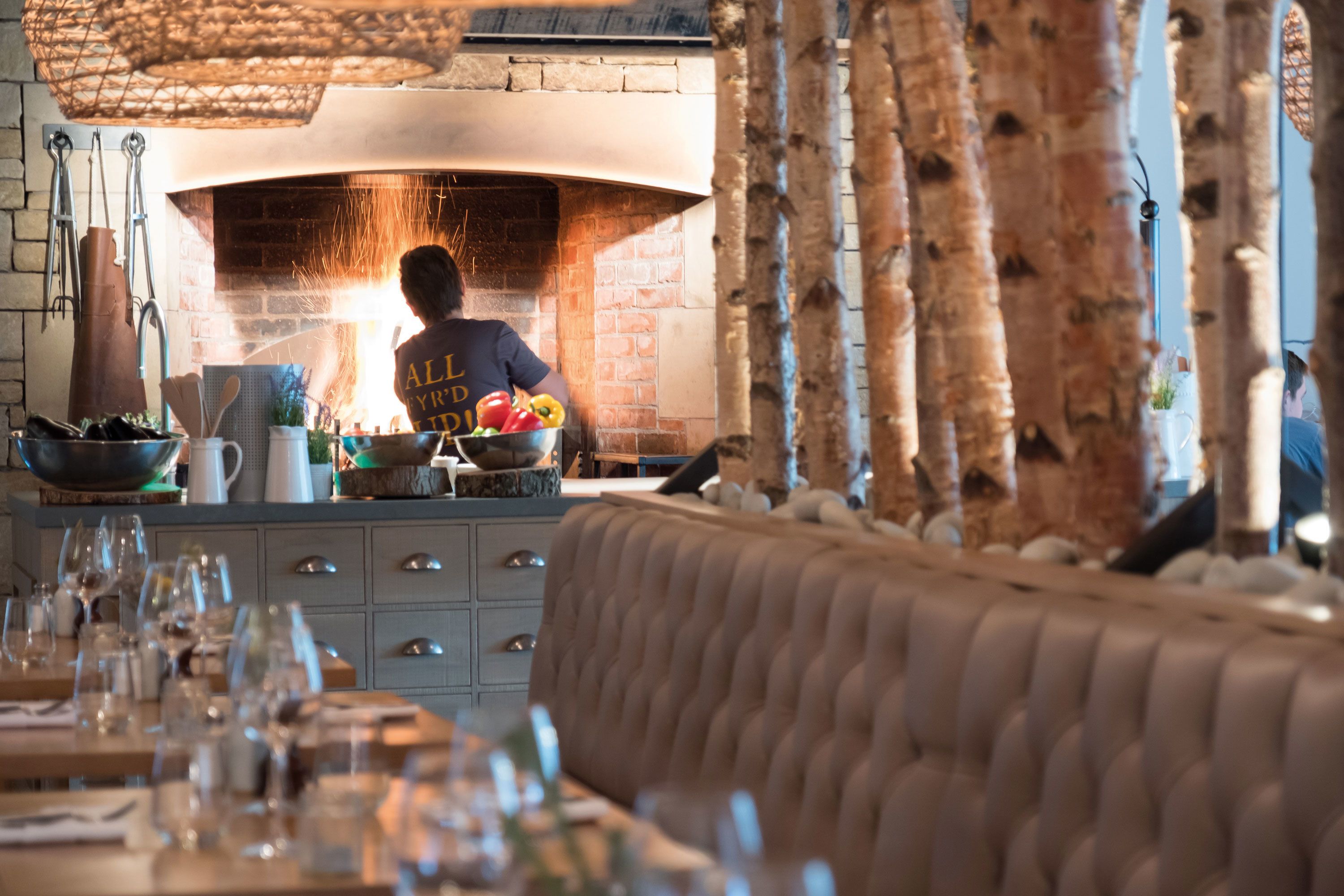 Un restaurant doté d’un four en briques, de tables en bois et d’un bar.