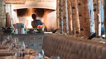Un restaurant doté d’un four en briques, de tables en bois et d’un bar.