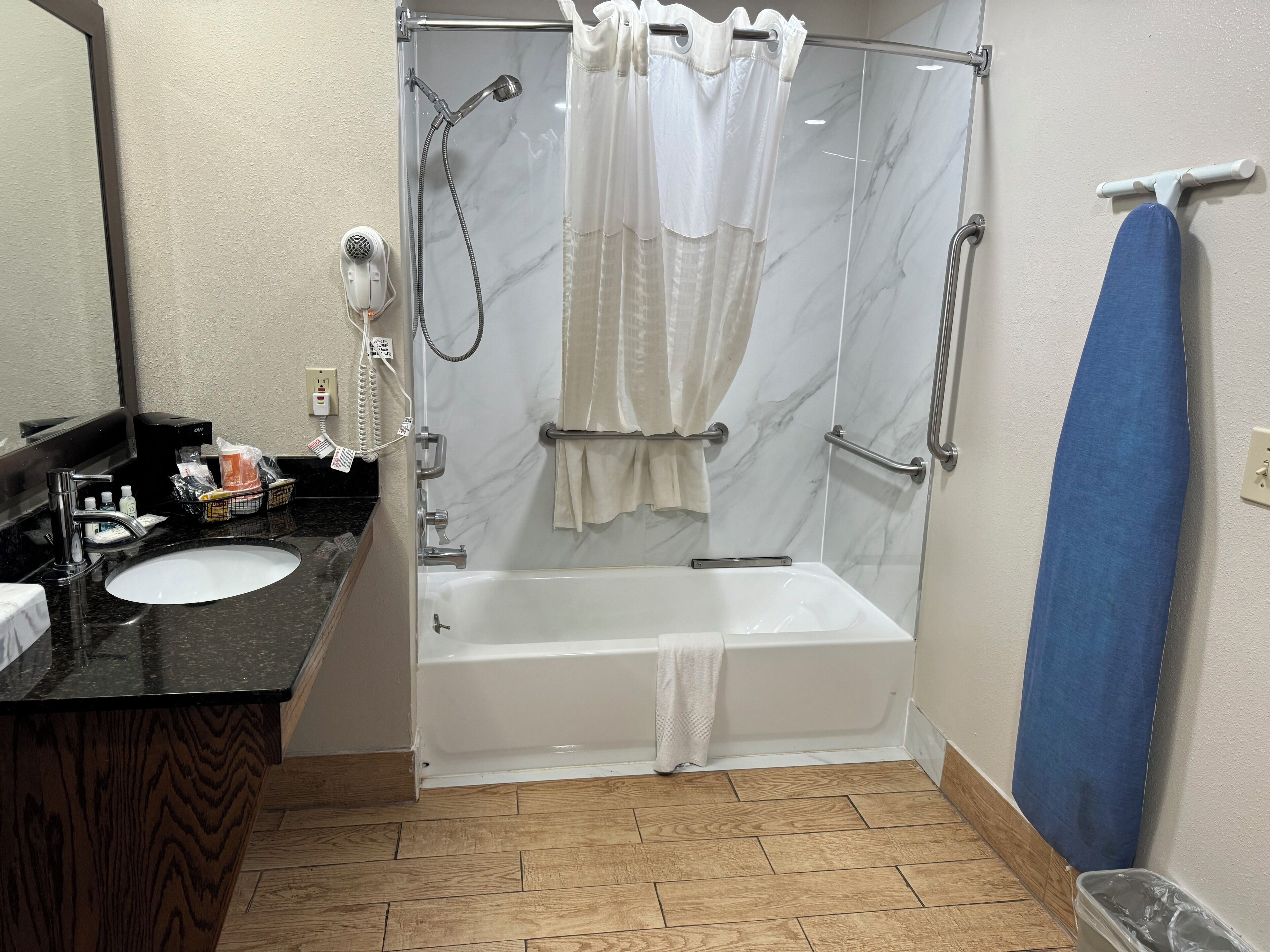 A bathroom with a shower, a sink, and a mirror.