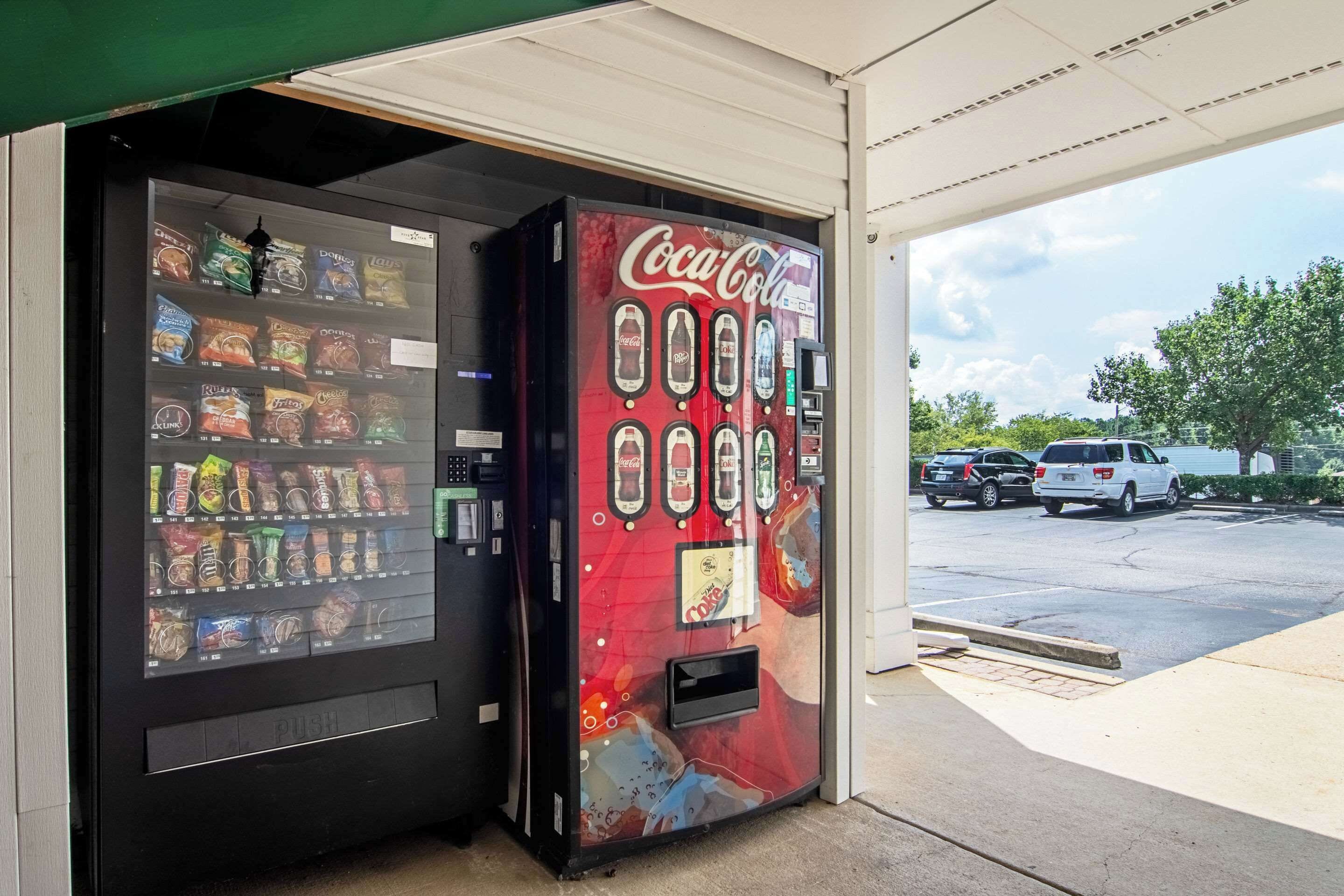 A vending machine with a Coca-Cola logo and a variety of snacks inside.