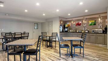 A modern kitchen with granite countertops, stainless steel appliances, and a wooden floor.