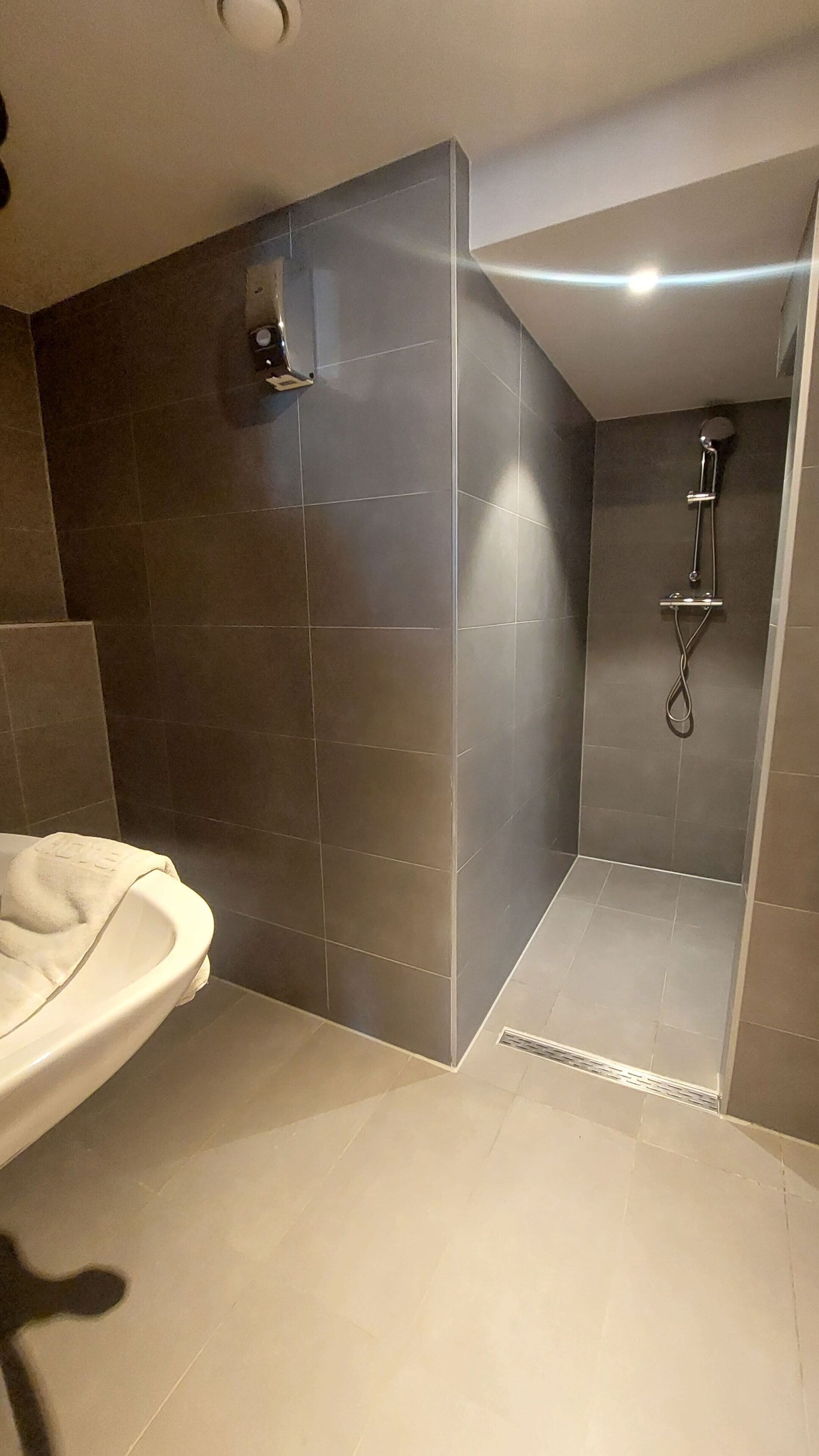A modern bathroom with a shower, a toilet, and a sink.