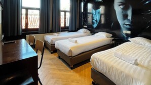 A hotel room with three beds, a desk, and a large mural on the wall. - Heart Of Amsterdam - Hostel (Amsterdam)