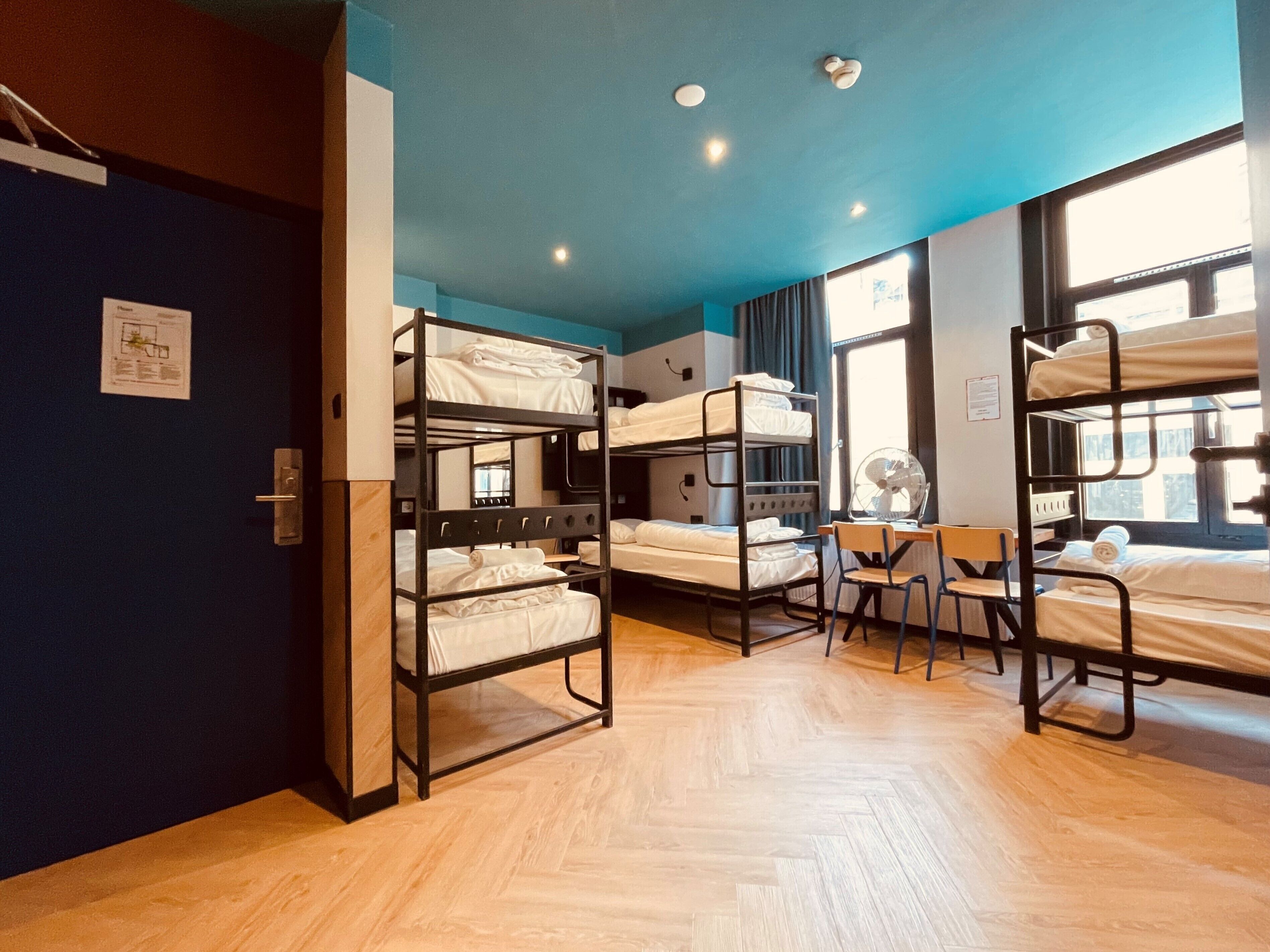 Une chambre de dortoir avec des lits superposés, un bureau et une chaise.