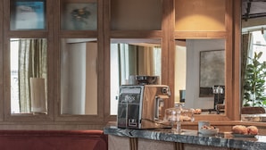 Una cocina acogedora con barra, taburetes de madera y un rincón de estar con sofá y sillones.