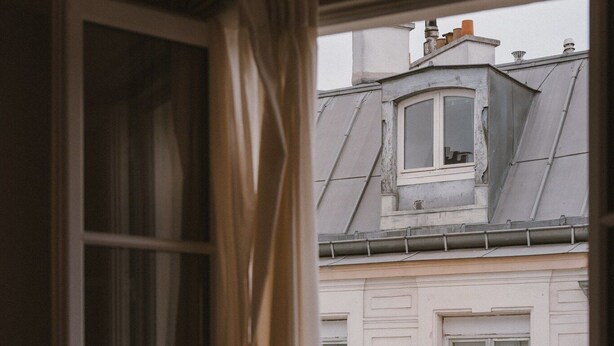 Una habitación con ventana que da a un edificio con balcón.