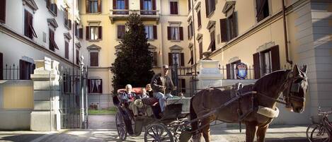 A horse-drawn carriage in a narrow street with buildings on either side.