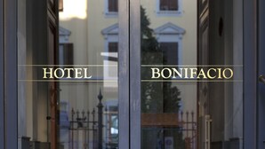 L’entrée d’un hôtel, avec l’inscription « HÔTEL BONIFACIO » visible sur les portes en verre.