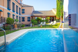 Una piscina al aire libre de temporada, tumbonas