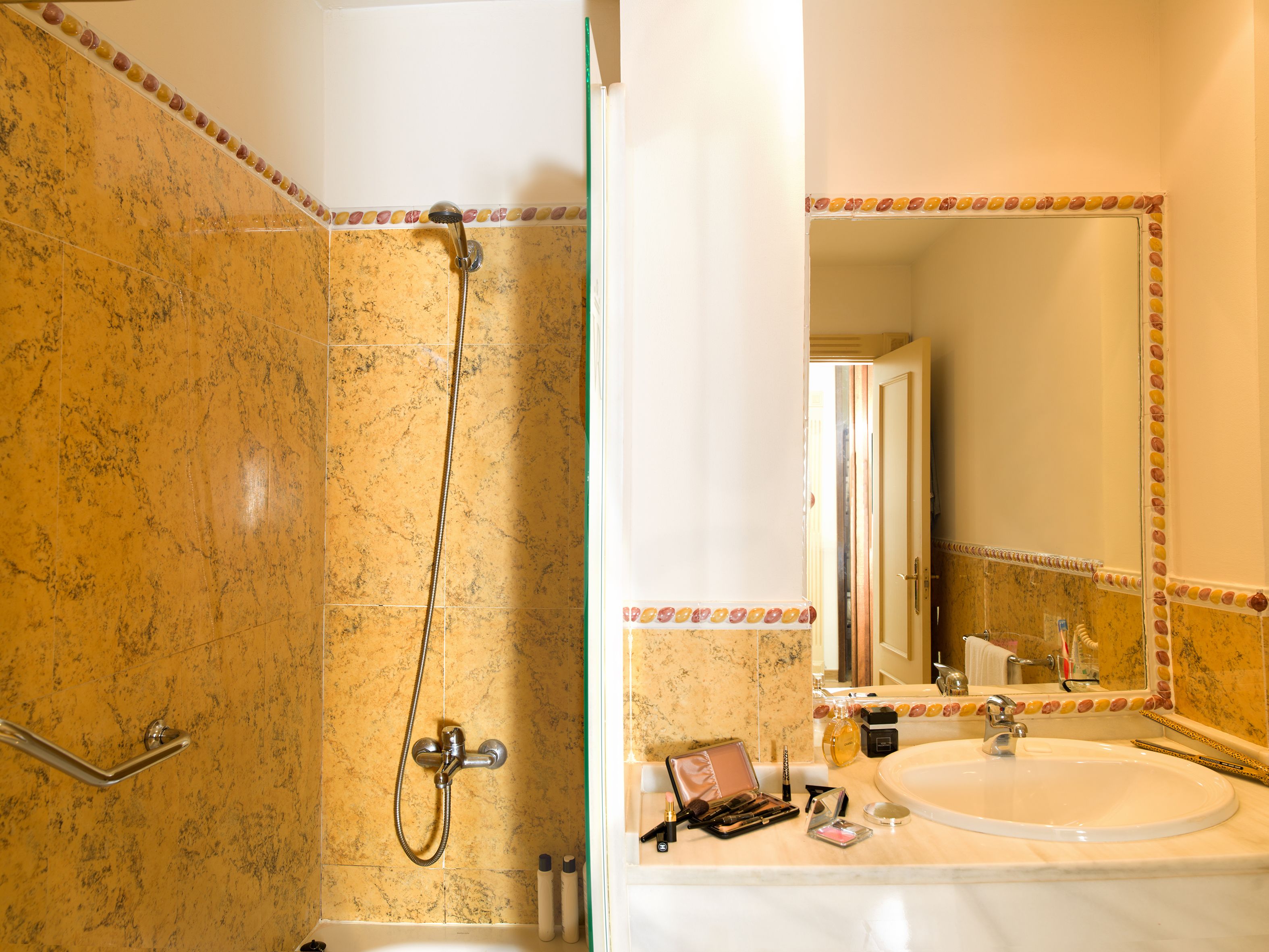 A bathroom with a shower, a sink, and a mirror.