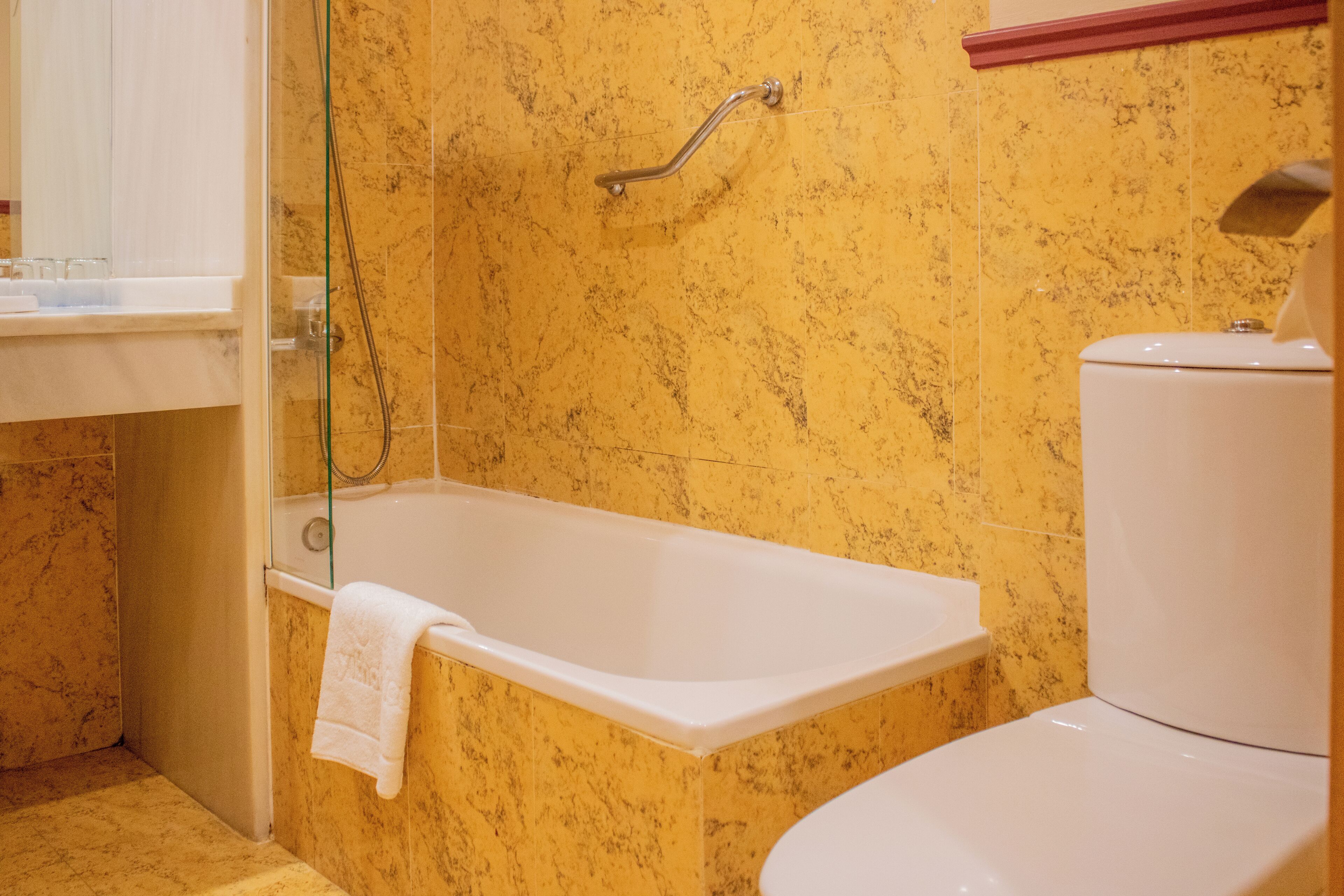 A bathroom with a bathtub, toilet, and a shower area.